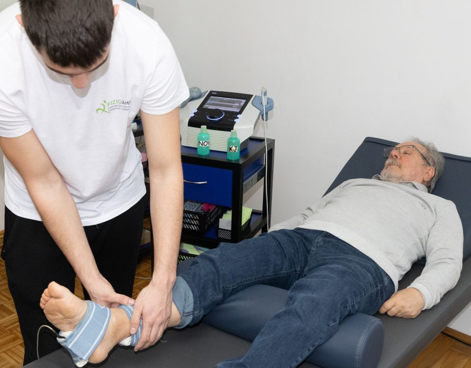 Fizioterapeut Fizio Ahila postavlja elektrode na skočni zglob pacijenta tokom elektroterapije u Beogradu