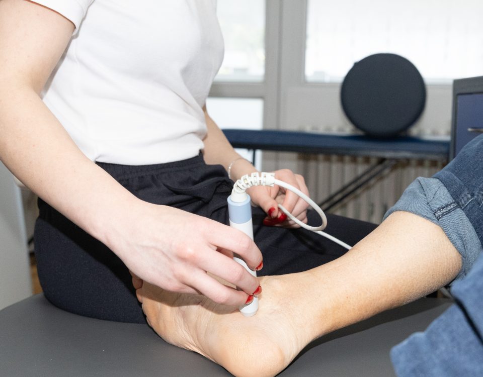 Fizioterapeutkinja primenjuje laseroterapiju na Ahilovu tetivu pacijenta, Fizio Ahil Beograd