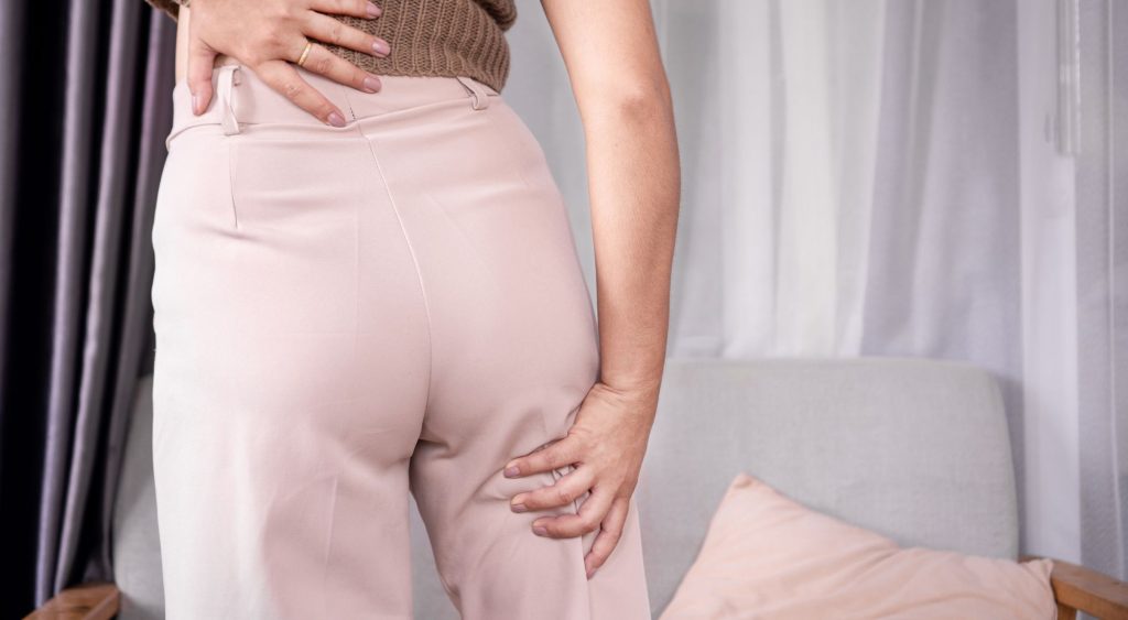 Žena drži donji deo leđa zbog pritiska na nervne korenove kičme koji se širi niz nogu